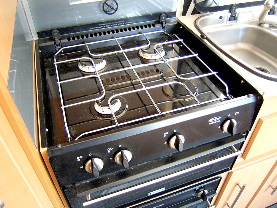 A close-up of the hob unit - with 3 gas burners and an electric hotplate.
